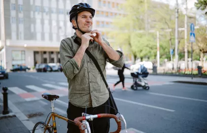 Een man naast een fiets zet een helm op